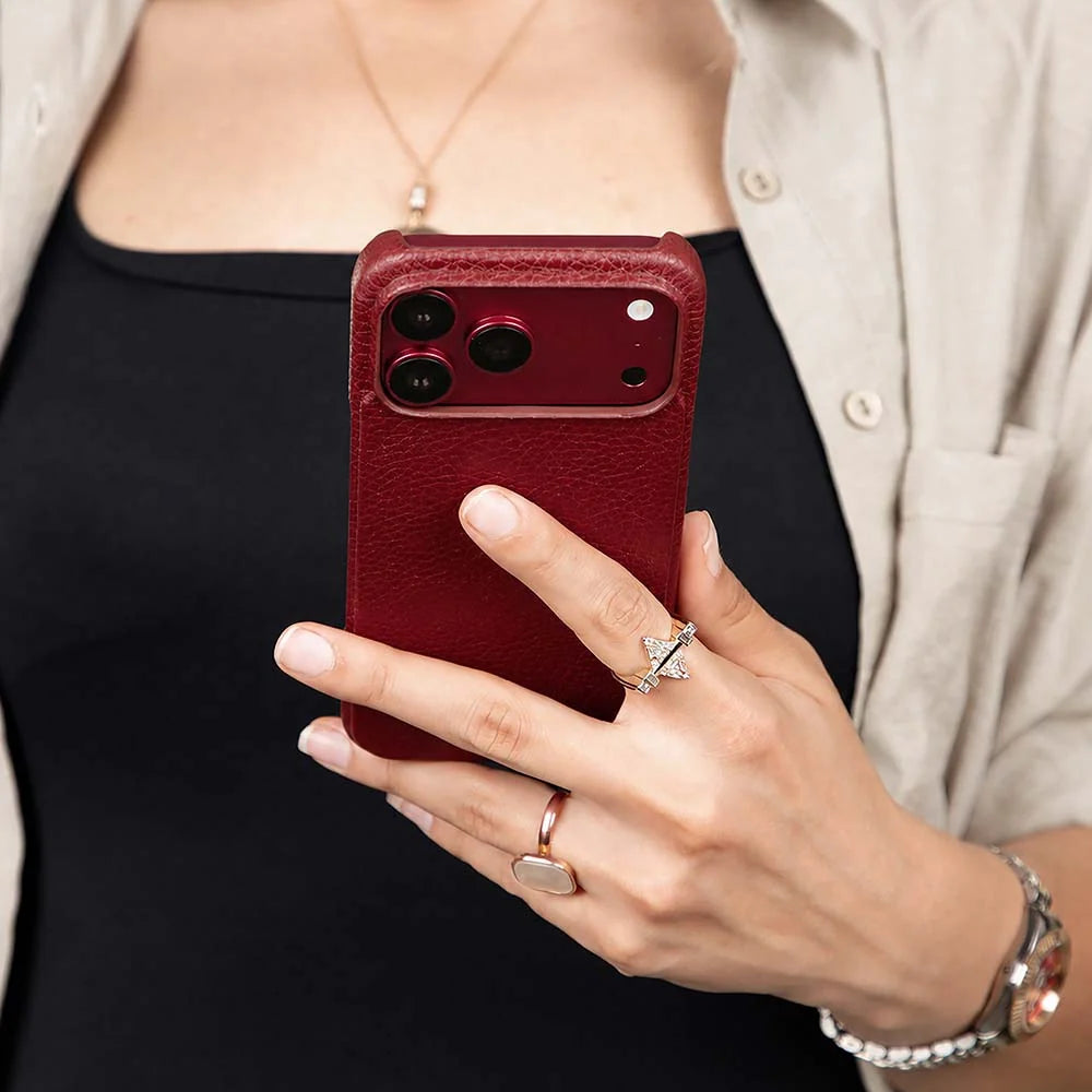 A woman holding a burgundy leather iPhone case